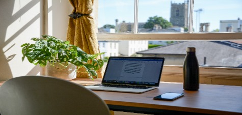 bureau met laptop, telefoon en waterfles