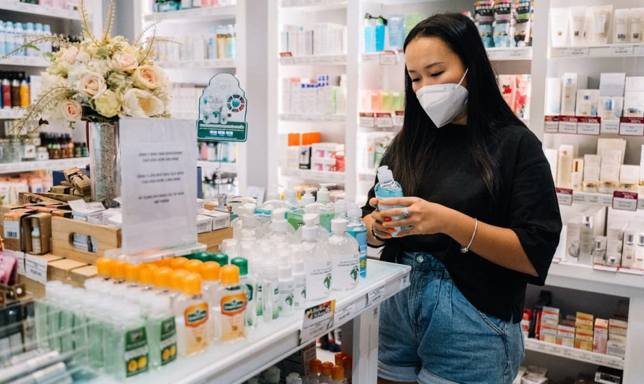 vrouw met mondkapje in apotheek