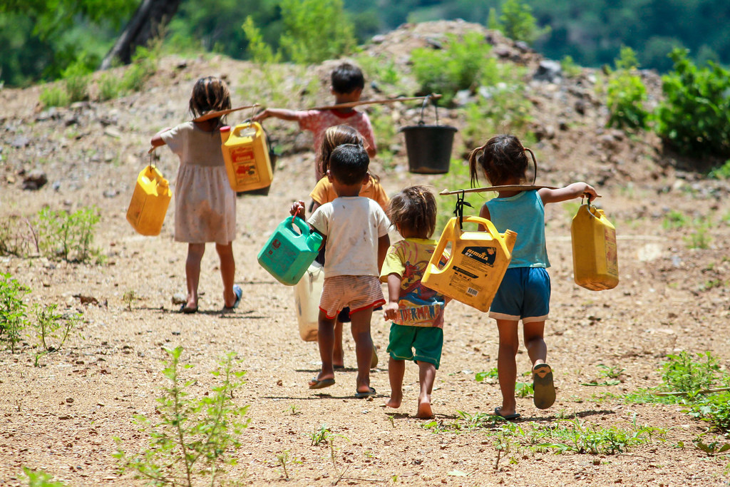 kinderen dragen water