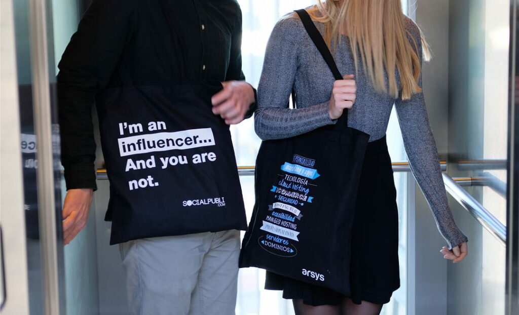 twee mensen die een bedrukte stoffen tas dragen