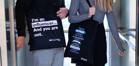 twee mensen die een stoffen tas met logo dragen