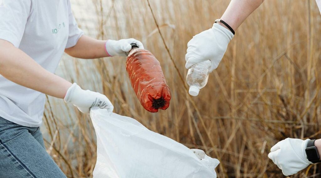 mensen die samen vuil oprapen en in een vuilzak steken