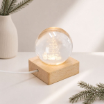 Glazen kerstbol met houten voet en warm licht