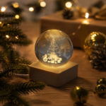 Glazen kerstbol met houten voet en warm licht