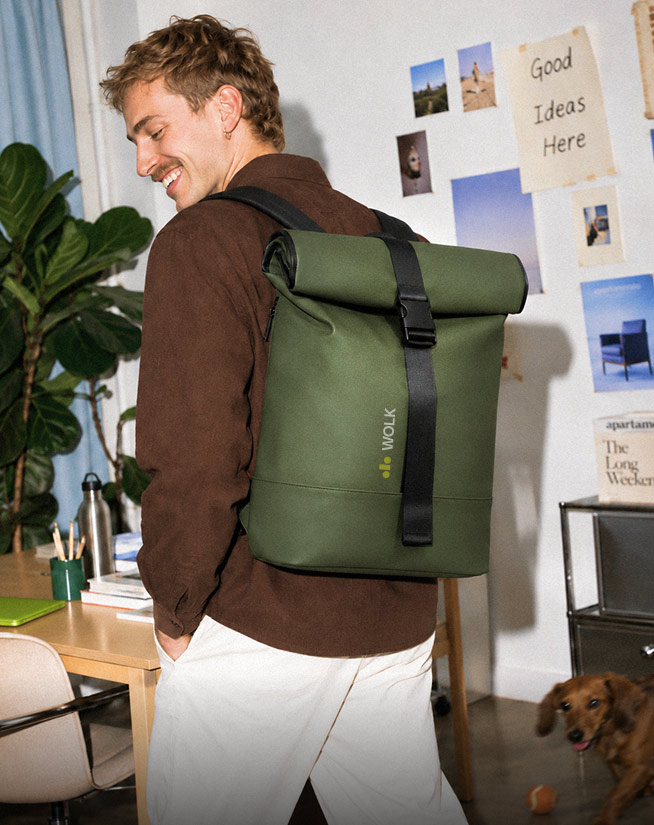 Man met olijfgroene roll-top laptoprugzak met bedrukt logo op kantoor